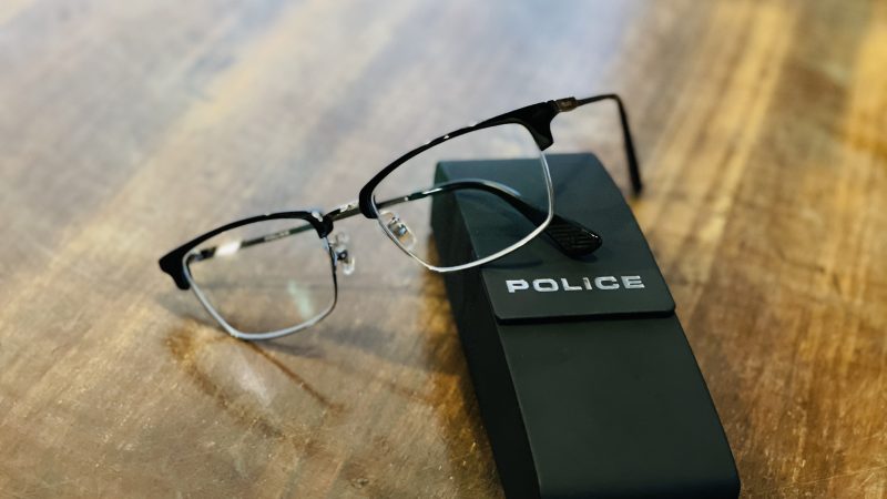 黒いケースに“POLICE”と書かれていて、その上に黒縁のメガネが置かれている