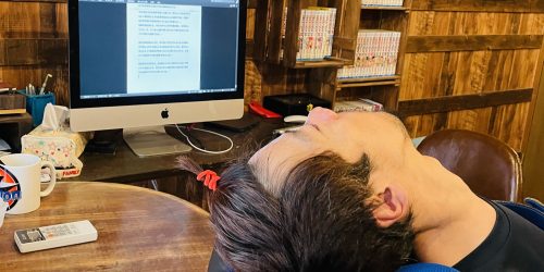 パソコンで小説を書いている、前髪を結んでいる僕