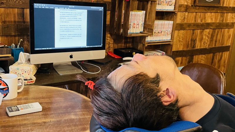 パソコンで小説を書いている、前髪を結んでいる僕
