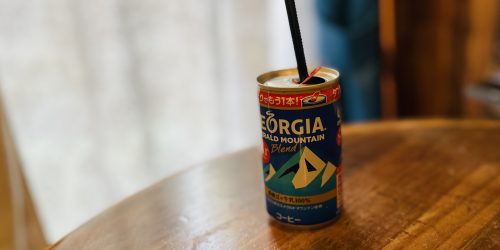 机の上に置かれている、ジョージアの缶コーヒー