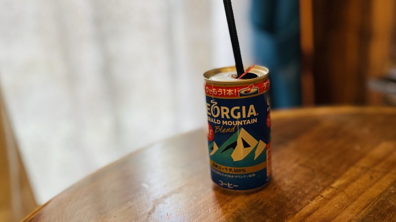 机の上に置かれている、ジョージアの缶コーヒー