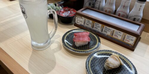 レモンサワーとマグロと帆立のお寿司が机に並んでいる写真