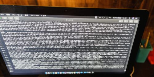 Macのモニターに写っている文章と、Mac本体の写真