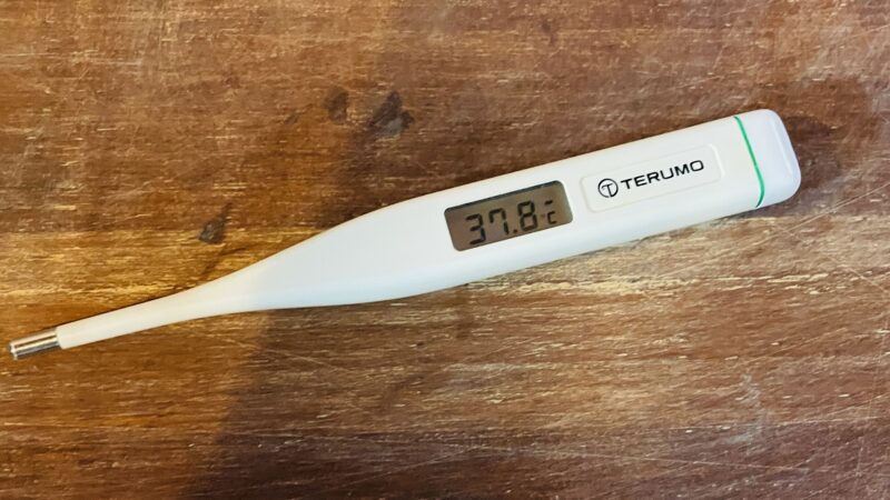 机の上に体温計が置かれ、37,8度と表示されているもの