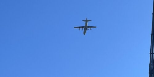 青空を飛んでいる飛行機が写っている写真