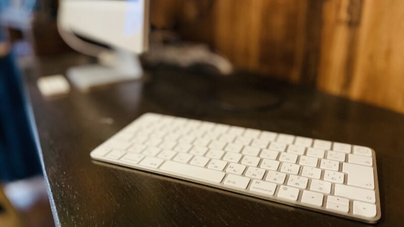 机の上にMacのキーボードが置いてある写真
