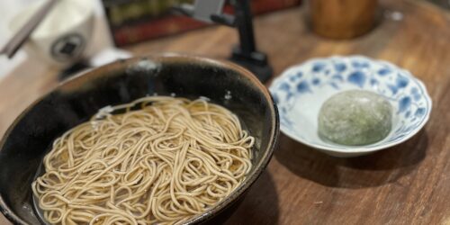 机の上に蕎麦と草大福が置いてある写真