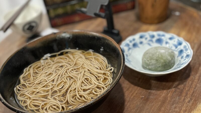 机の上に蕎麦と草大福が置いてある写真