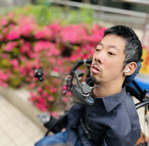 花を背にしている僕の写真