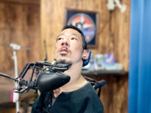 “My Action”のロゴを背にしている僕