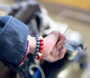 右手に赤い数珠と青い数珠が付いている写真