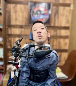 “My Action”のロゴを背にしている僕