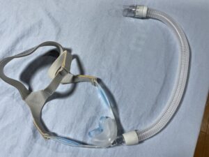 ベッドの上にある呼吸器のマスク