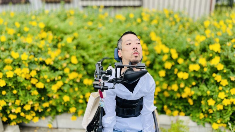 黄色い花の前にいる僕
