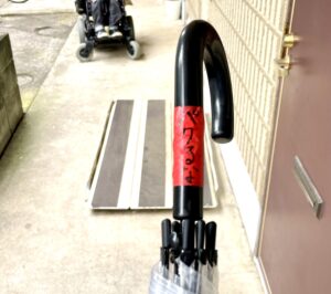 赤いテープに“パクるな”と書いてある傘の写真