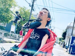 ノースリーブの上に赤いシャツを羽織っている僕